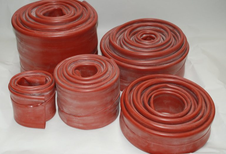 Various sizes of rolled red silicon sleeve arranged in a group.