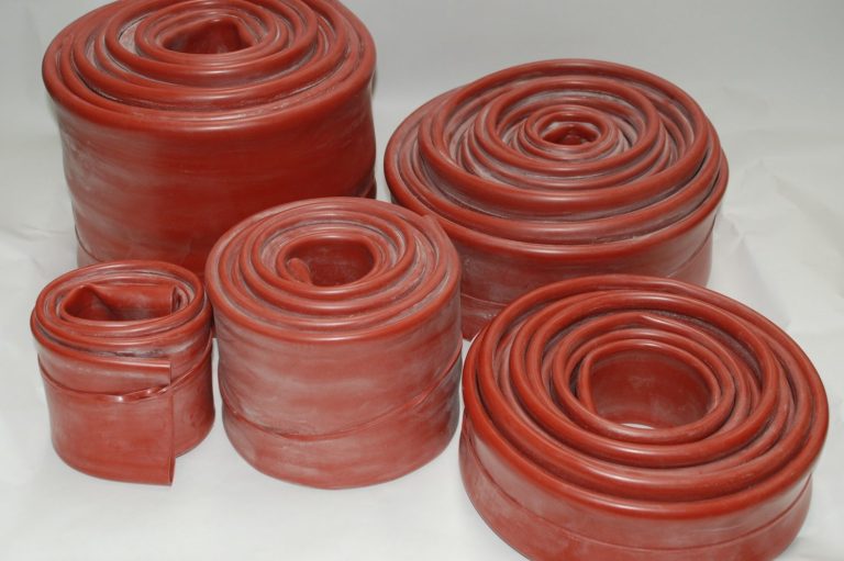 Various sizes of rolled red silicon sleeve arranged in a group.