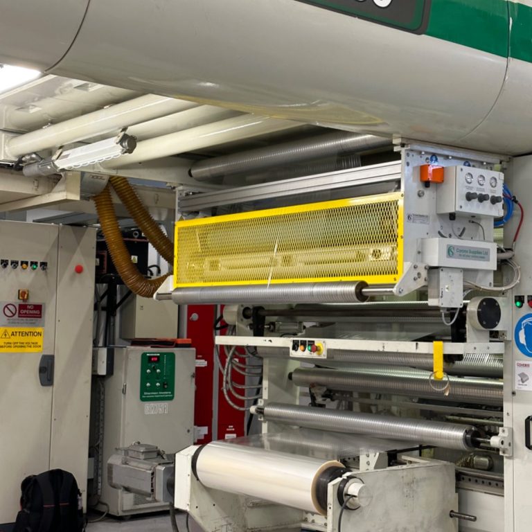 Close-up of a laminating  machine with a Corona Treater fitted with safety guards and control panel.