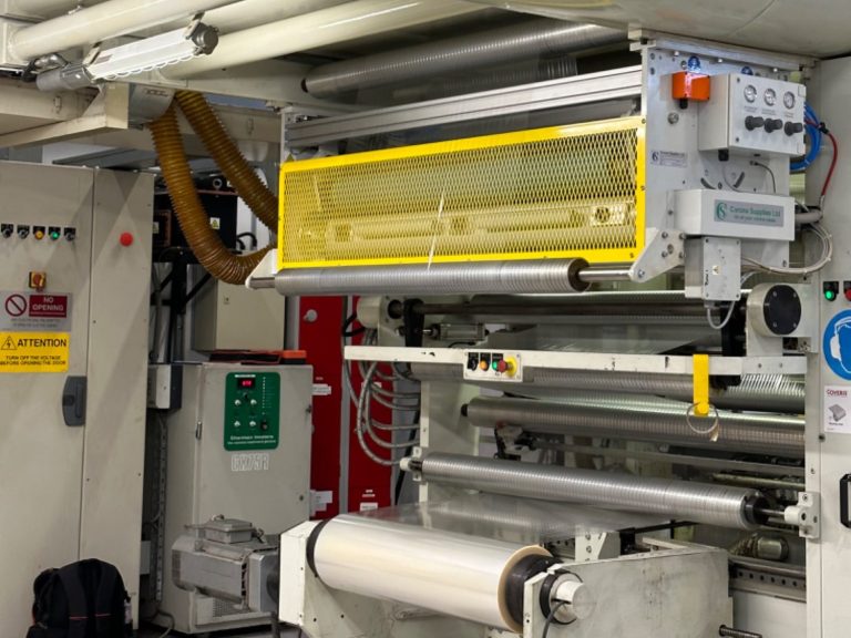 Close-up of a laminating  machine with a Corona Treater fitted with safety guards and control panel.