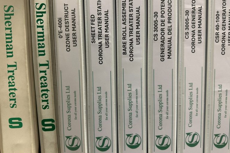 Row of white binders labelled "Sherman Treaters" and "Corona Supplies".