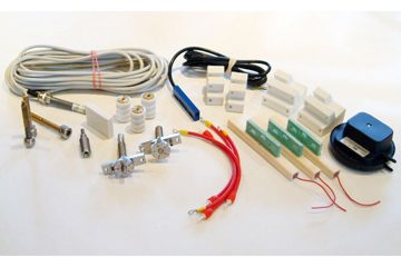 Assorted spare parts for corona treaters, including wires, connectors, and mounting accessories.