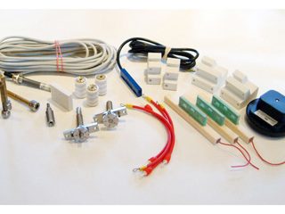 Assorted spare parts for corona treaters, including wires, connectors, and mounting accessories.