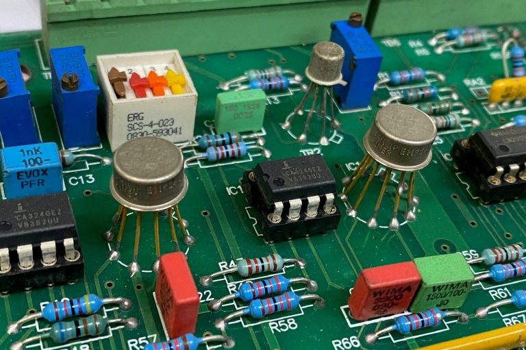 Close-up of a circuit board with various electronic components and colour-coded resistors.